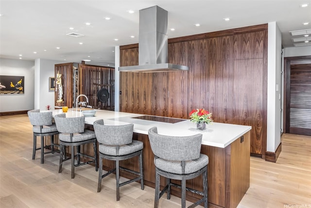 41-471 Kalanianaole Hwy, Waimanalo, HI 96795 - kitchen with island exhaust hood, black electric cooktop, modern cabinets, light wood-type flooring, and light countertops