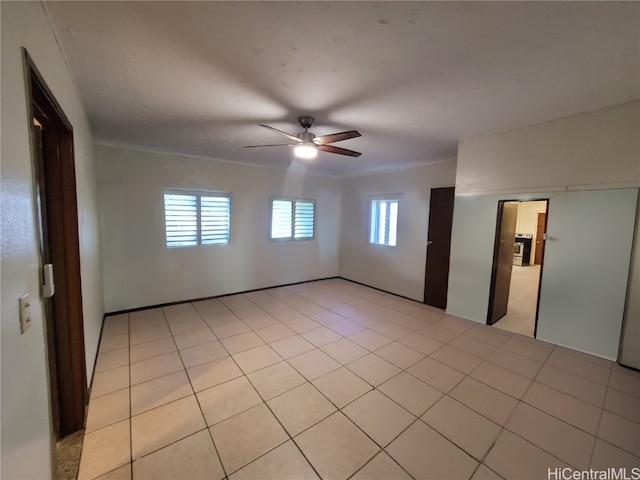 empty room with light tile patterned flooring and ceiling fan