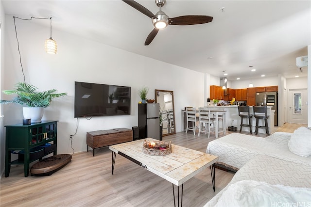 living room with light hardwood / wood-style floors and ceiling fan