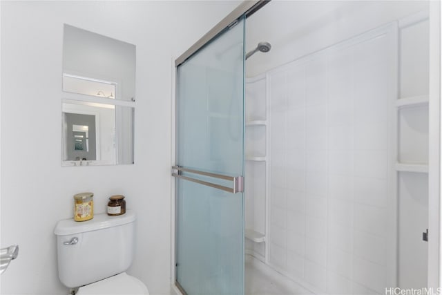 bathroom with toilet and a shower with shower door