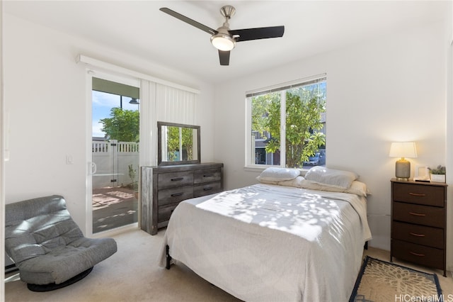 bedroom with ceiling fan, multiple windows, and light carpet