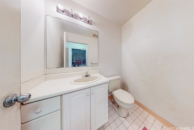 bathroom featuring tile patterned flooring, vanity, and toilet