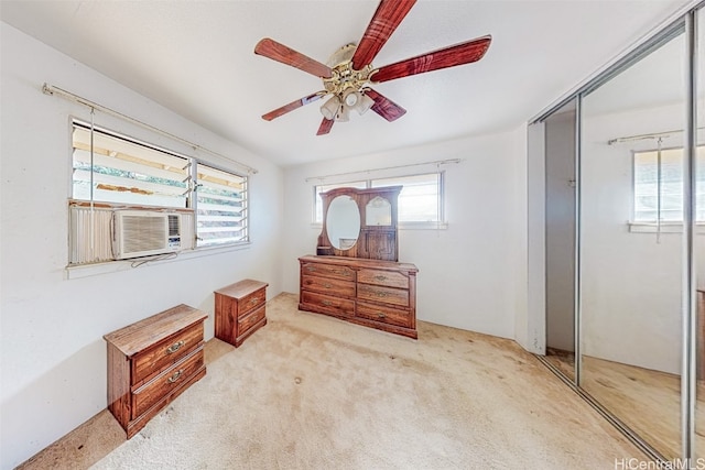 bedroom featuring light carpet, a closet, multiple windows, and ceiling fan