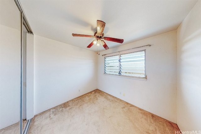 unfurnished bedroom featuring ceiling fan, light carpet, and a closet