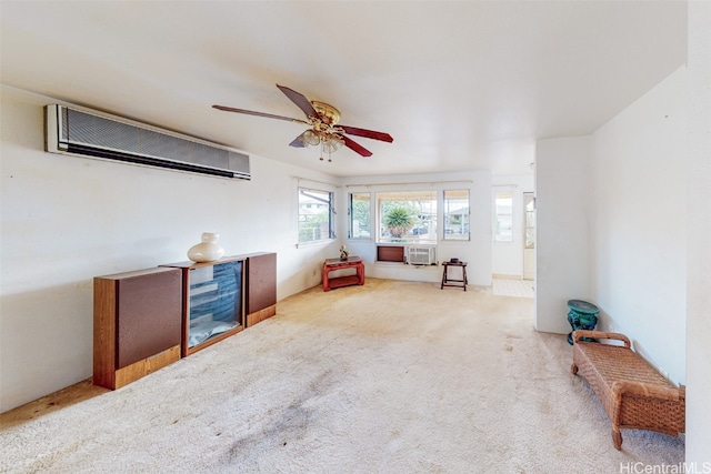 living room with a wall mounted AC, ceiling fan, and carpet