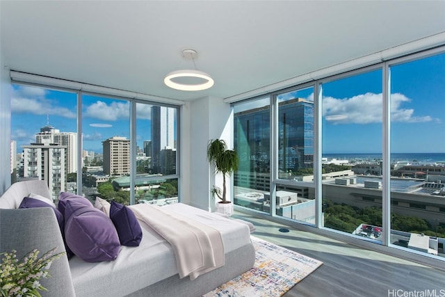 bedroom featuring hardwood / wood-style floors, a water view, and floor to ceiling windows