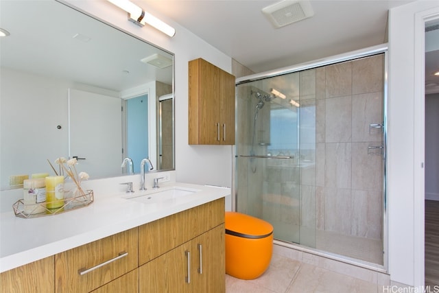 bathroom featuring vanity, tile patterned floors, and a shower with shower door