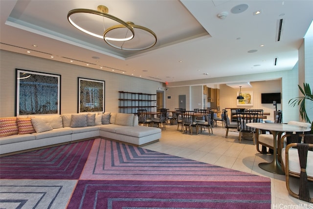 living room with light tile patterned flooring and a raised ceiling