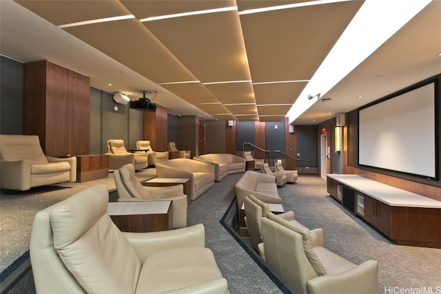 carpeted cinema room featuring wood walls