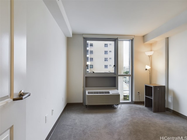 carpeted spare room featuring a wall mounted AC