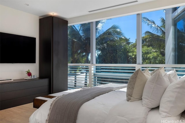 bedroom with hardwood / wood-style floors and multiple windows