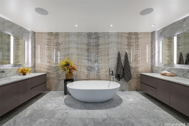 bathroom featuring a wealth of natural light, vanity, and tile walls