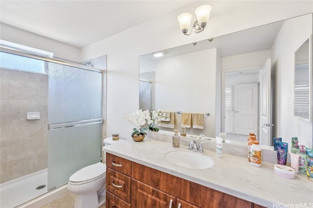 bathroom featuring toilet, vanity, tile patterned floors, and a shower with shower door