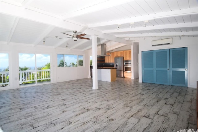 unfurnished living room with ceiling fan, lofted ceiling with beams, a healthy amount of sunlight, and light hardwood / wood-style flooring