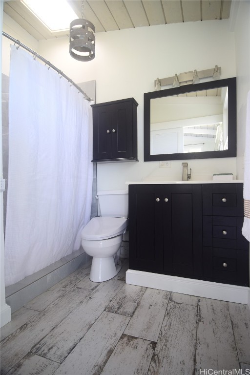 bathroom featuring toilet, lofted ceiling, wood ceiling, and vanity