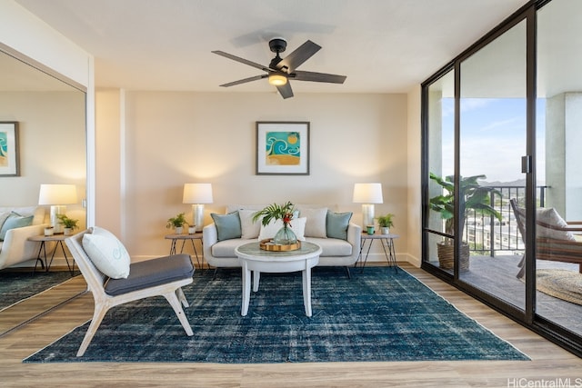 sitting room featuring ceiling fan, light hardwood / wood-style flooring, and floor to ceiling windows