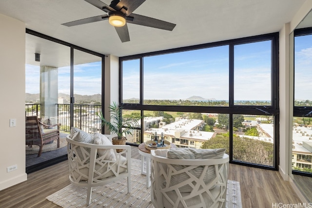 sunroom / solarium featuring a mountain view, a healthy amount of sunlight, and ceiling fan