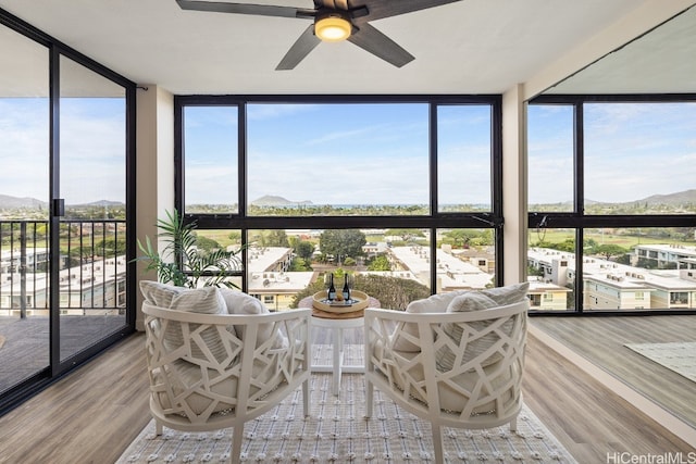 sunroom with a mountain view and ceiling fan