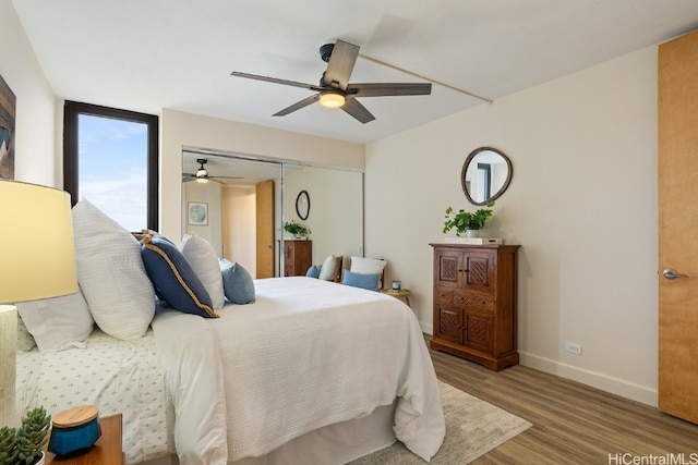 bedroom with wood-type flooring, ceiling fan, and a closet