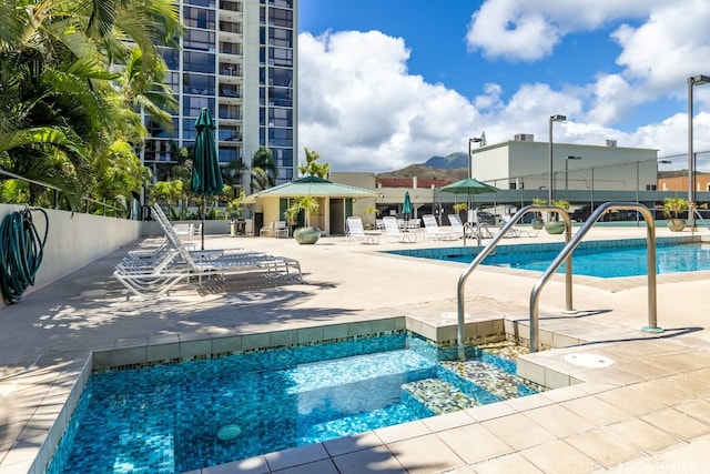 view of pool with a patio area and a community hot tub