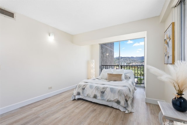 bedroom featuring a mountain view and light hardwood / wood-style floors