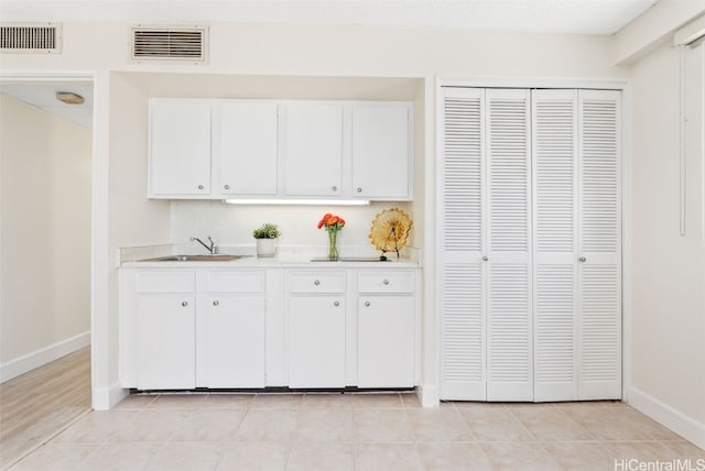 kitchen featuring sink, white cabinets, and light tile patterned floors