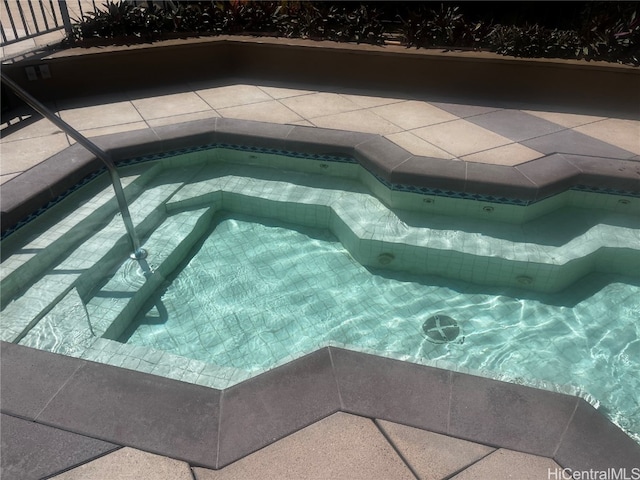 view of pool with an in ground hot tub