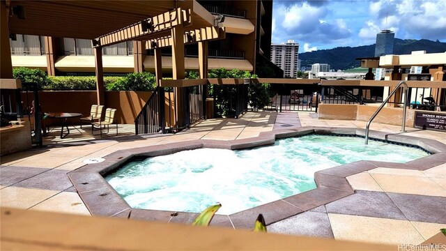 view of swimming pool with a mountain view and a community hot tub