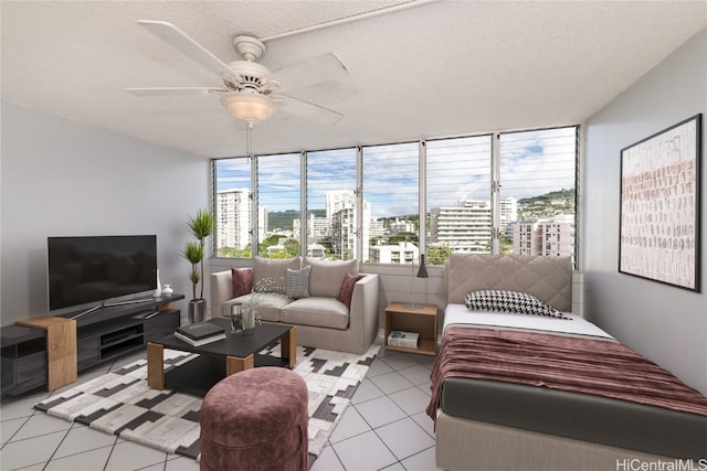 interior space with a textured ceiling, light tile patterned floors, and ceiling fan