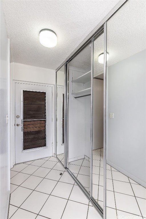 interior space featuring a textured ceiling and light tile patterned floors