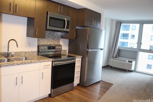 kitchen with sink, appliances with stainless steel finishes, backsplash, white cabinets, and dark wood-type flooring