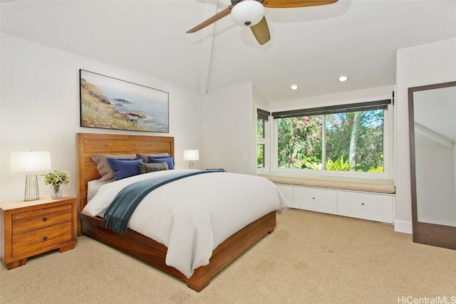 bedroom with ceiling fan, beam ceiling, and light carpet