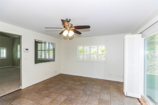 empty room with ceiling fan and light tile patterned floors