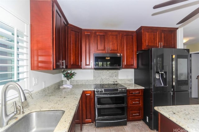 kitchen featuring light stone countertops, stainless steel appliances, ceiling fan, sink, and light tile patterned floors