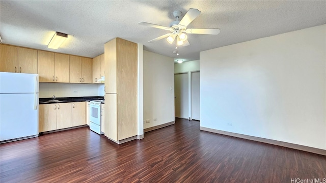 kitchen with dark hardwood / wood-style flooring, a textured ceiling, white appliances, and sink