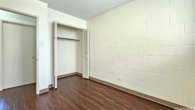 unfurnished bedroom featuring dark wood-type flooring and a textured ceiling