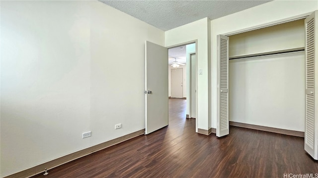 unfurnished bedroom featuring dark hardwood / wood-style floors, a textured ceiling, and a closet