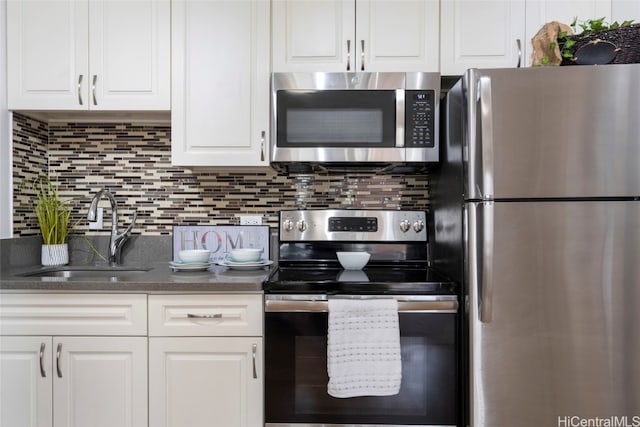 kitchen featuring white cabinets, appliances with stainless steel finishes, sink, and tasteful backsplash