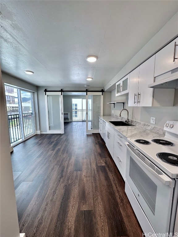 kitchen with white range with electric cooktop, dark wood-type flooring, white cabinets, a barn door, and sink