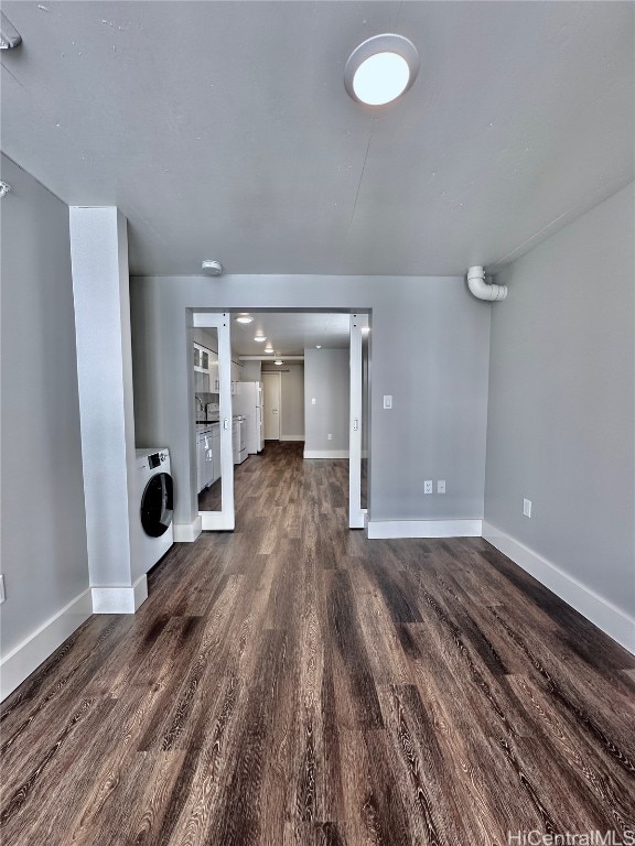 unfurnished living room featuring dark hardwood / wood-style floors and washer / clothes dryer