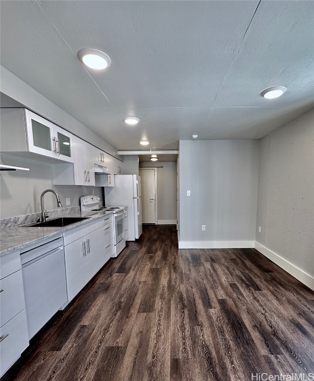 kitchen with white appliances, white cabinetry, sink, and dark hardwood / wood-style flooring