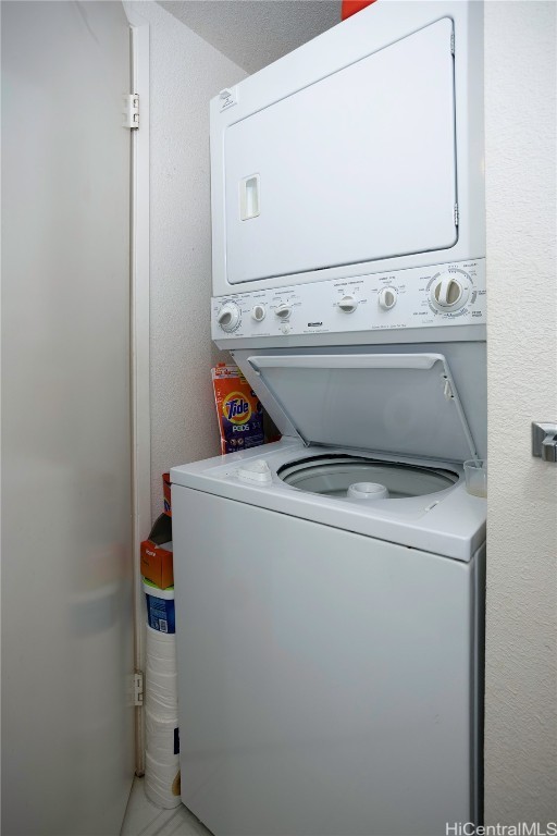 clothes washing area with stacked washer and dryer