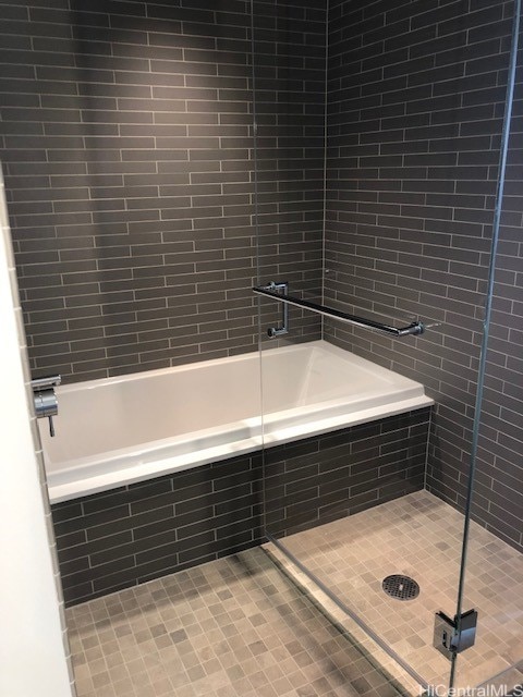 bathroom with combined bath / shower with glass door