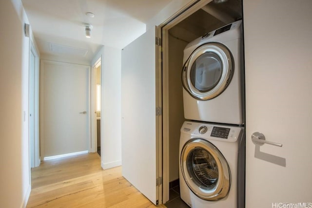 washroom featuring light hardwood / wood-style floors and stacked washer and clothes dryer