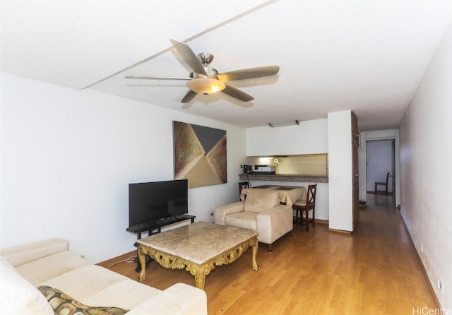 living room featuring hardwood / wood-style floors and ceiling fan