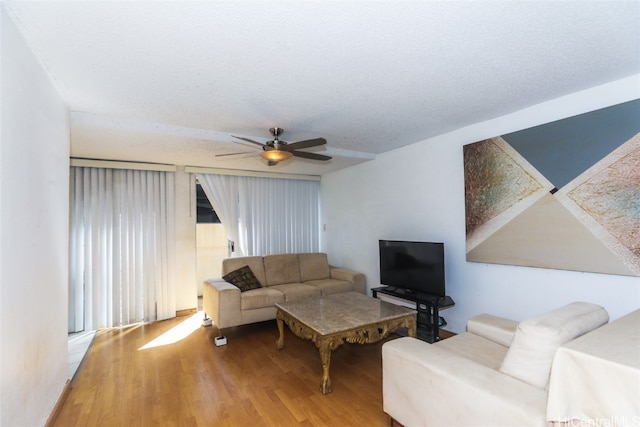 living room featuring ceiling fan, a textured ceiling, and hardwood / wood-style flooring