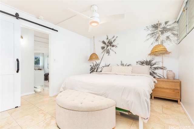 bedroom with ceiling fan, a barn door, light tile patterned flooring, and connected bathroom