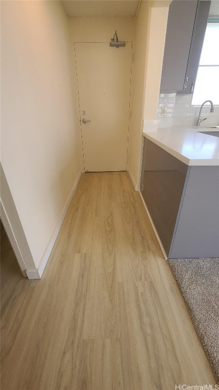 hallway featuring light wood-type flooring and sink