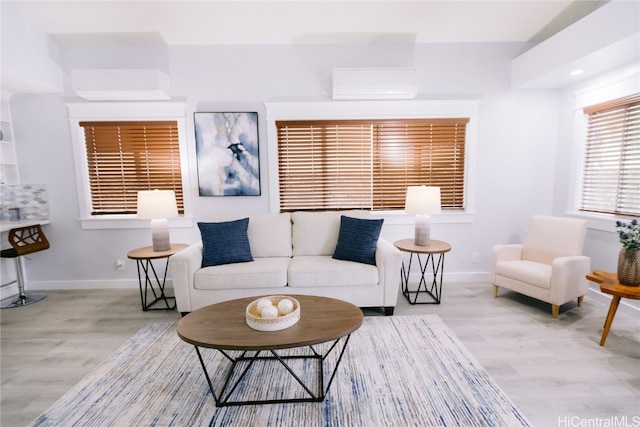 living room with a wall mounted AC and light hardwood / wood-style floors