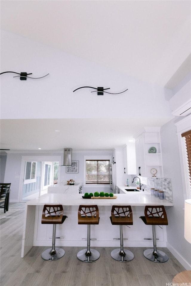 92-1310 Palahia St, Kapolei, HI 96707 - kitchen featuring a sink, exhaust hood, light wood-type flooring, white cabinets, and a wall unit AC
